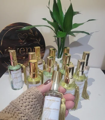 Frasco de perfume para cabelo de 70 ml com válvula spray dourada e pingente de seda decorativo.