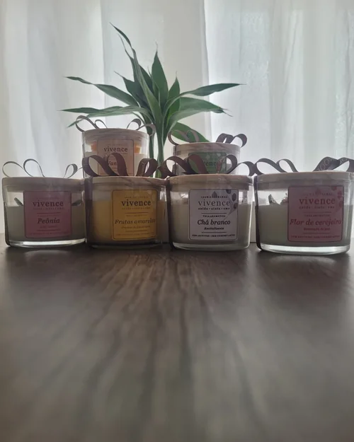 Preparação artesanal de velas aromáticas e lembrancinhas personalizadas com laços manuais no ateliê Vivence.